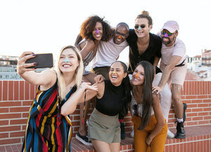 Group of friends having fun, taking a selfie while displaying their colorful sunscreen on their nose.  